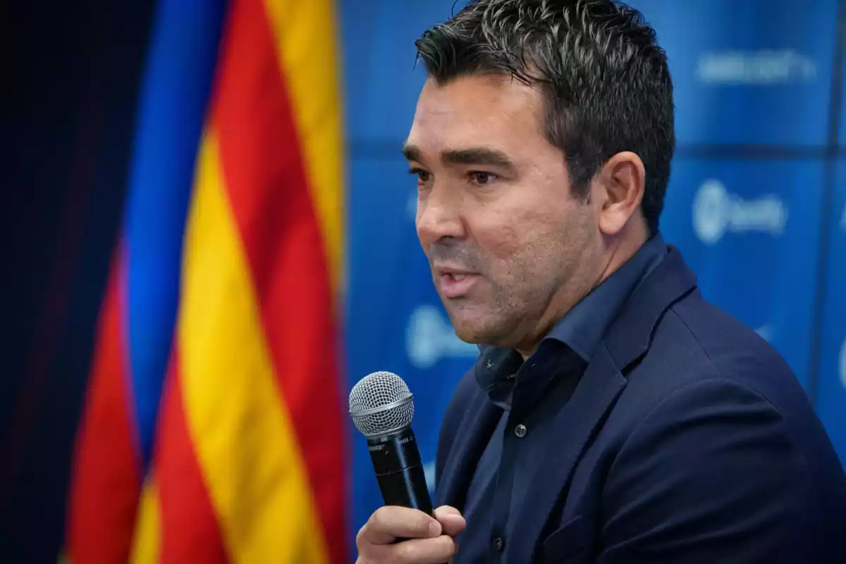 Deco chatting with a microphone in his hand at a FC Barcelona press conference.